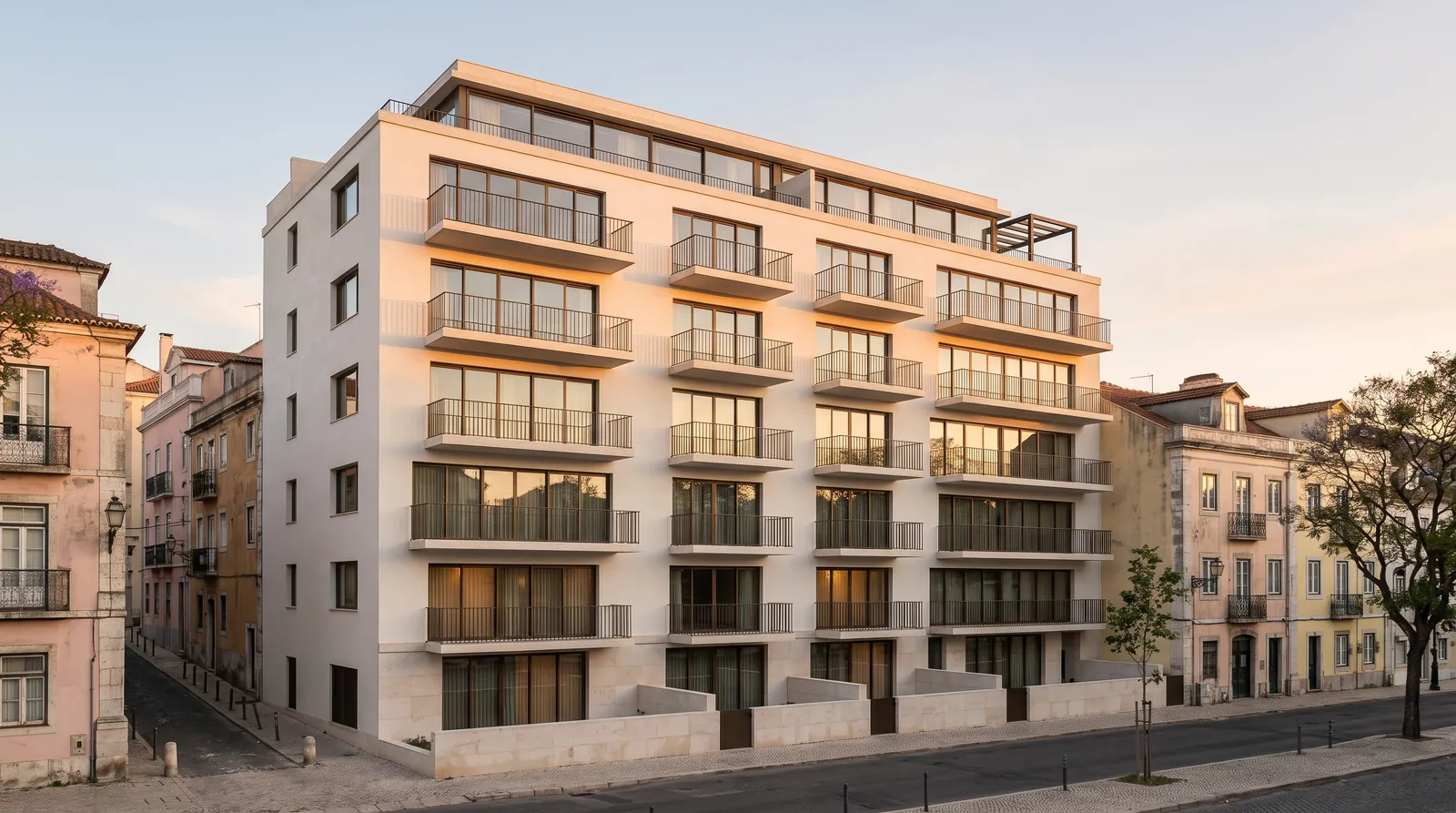 Corvela Residences at golden hour: a seven-storey white building with stone base and slender balconies on a Lisbon street — illustrative visualisation